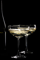 Two glasses of sparkling champagne infront of black background