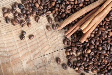 coffee beans with cinnamon on wooden table