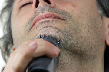 Obraz premium close up of man with electric razor