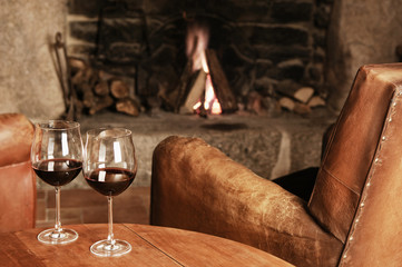 Two Glasses Of Red Wine At A Cosy Fireplace
