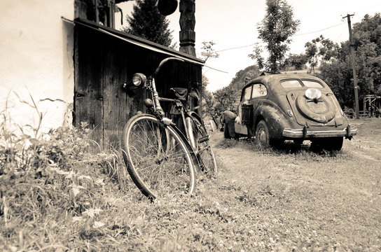 Old sepia vintage car and bicycle in the village