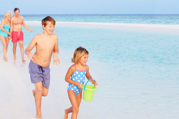 Naklejka premium Grandparents And Grandchildren Having Fun On Beach Holiday