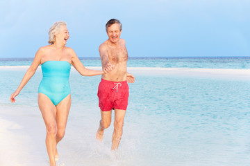 Senior Couple Splashing In Beautiful Tropical Sea