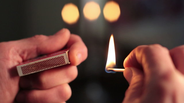 Close up of hands lighting a match