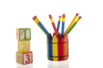 Collage of colourfull pencils in a cup next to three 1-2-3 cubes