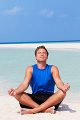 Fototapeta na wymiar Man Meditating On Beautiful Beach