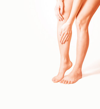 woman holding sore leg, on a white background