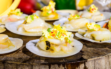 Raw Scallops topped with butter, garlic and parsley on Chopping
