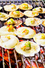 Grilled scallops topped with butter, garlic and parsley on flami