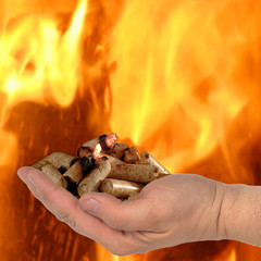 Hand mit brennenden Holzpellets, Feuer und Glut