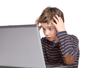 Junge / Jugendlicher blickt schockiert auf Notebook / Laptop