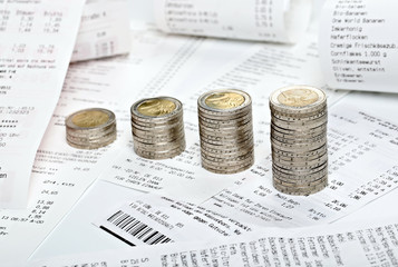 M&uuml;nzenstapel mit Supermarkt-Rechnungen