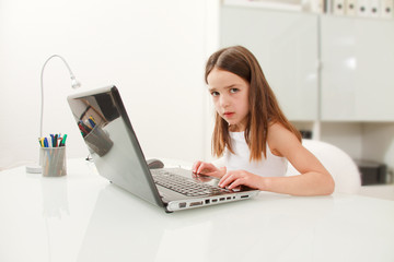 Mädchen macht Aufgaben am Laptop