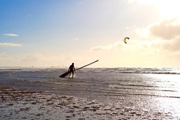 kitesurfer on beach in waves