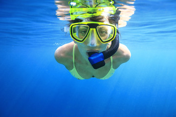 Young woman doing snorkeling in the blue ocean