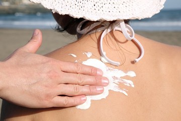 applying sun creme on the shoulder of a woman