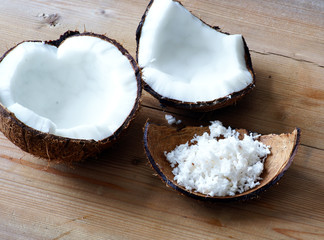 Kokosnuss mit Kokosraspeln auf Holzbrett