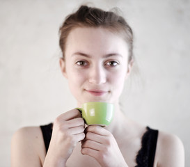 young Woman holding a green Cup