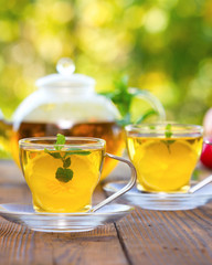 Two cups of mint tea with honey and lemon