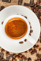 Espresso, cup of coffee, spilled coffee beans, top view