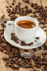 Obraz na płótnie Canvas Espresso, filiżanka kawy, ziarna kawy rozlana