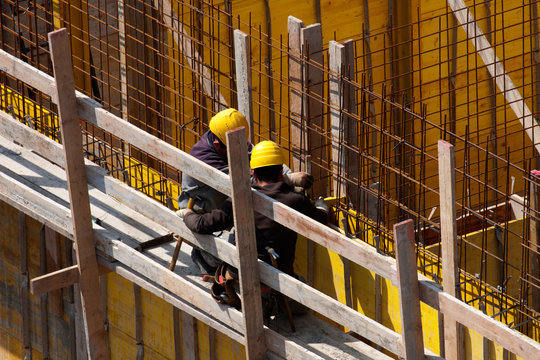 Specialists carpenters work on reinforcement armor at construction site with individual protections