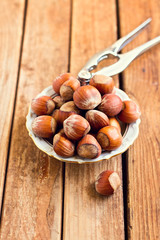 Hazelnuts on plate over wooden background