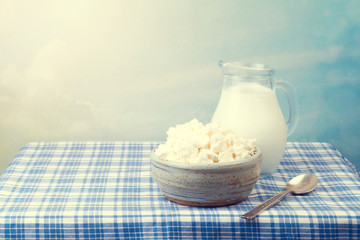 Cottage cheese and milk on tablecloth over beautiful background