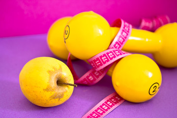 fit life: dumbbells, measuring tape and apple