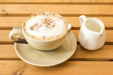 A cup of coffee latte on a wooden table in an cafe.