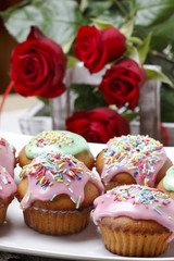 Muffins with pink icing and colorful sprinkles