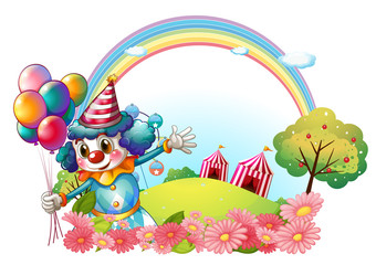 A female clown at the hill with a rainbow