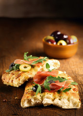 Serving of focaccia bread with ham and rocket