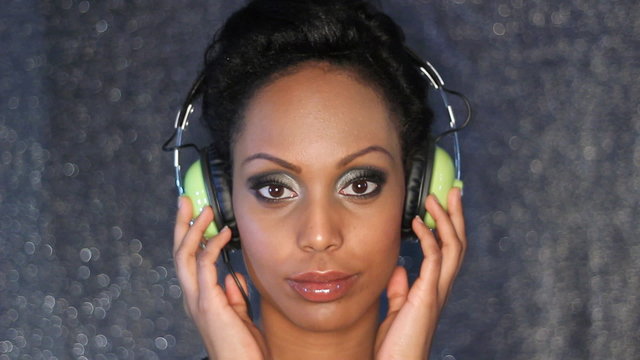 Young woman listens to headphones. Stop action effect.