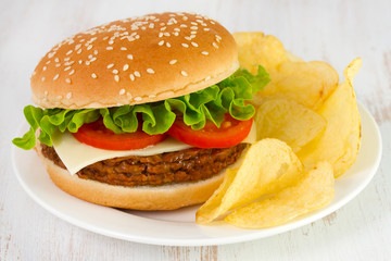 cheeseburger with chips on the plate