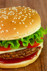 cheeseburger with lettuce on old table