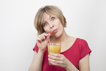 woman with big eyes drinking juice with straw