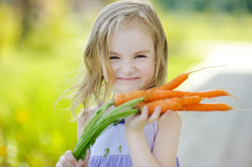 Adorable little girl with carrots