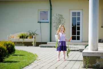 Fototapeta na wymiar Adorable little girl with carrots