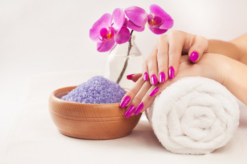 Fototapeta na wymiar female hands with fragrant orchid and towel. Spa