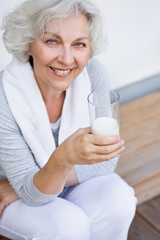 sportliche Seniorin mit einem Glas Milch
