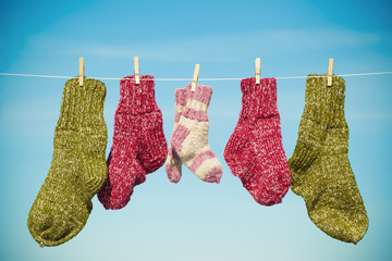 Three pairs of woolen socks hanging on rope