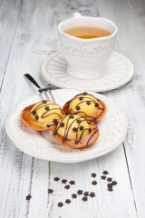 Sweet cakes with a cup of tea on a white table