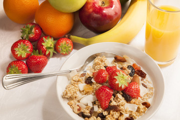 Bowl of cereal and fruits on tabletop - breakfast.