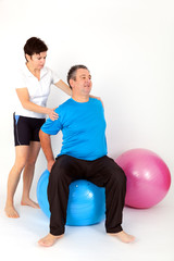 Woman helping man with exercise ball during the exercise