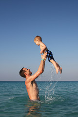 Father and son playing in the ocean