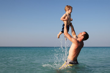 Fototapeta na wymiar Father and son playing in the ocean