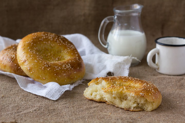 Fresh pitas bread, ears of rye and milk jug.