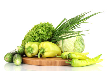 fresh green vegetables on chopping board isolated on white