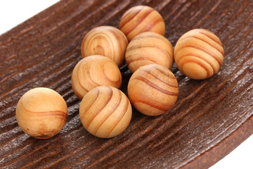 Wooden balls in decorative plate close-up.